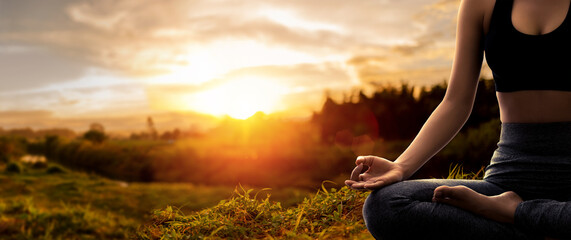 Young woman practicing yoga in sunset time
