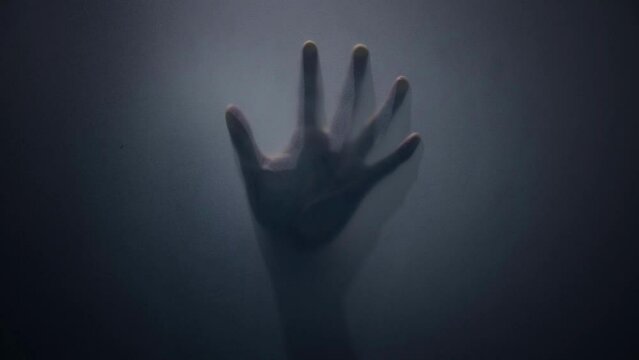 Hand silhouette on mirror, horror movie concept spooky hand slowly moving behind shower curtain in bathroom