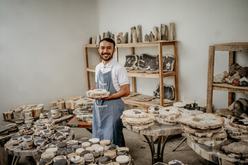 smiling stone craft shop worker man holding cut stone crafts in the warehouse