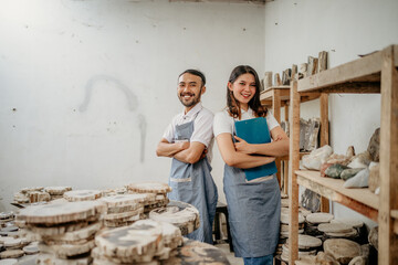 smiling young man and young woman stone craft entrepreneurs with arms crossed in a craft shop