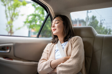 Relaxing moment of beautiful woman sleeping in car back seats with safety belt. Female happy in car...