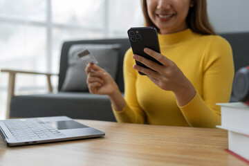 Asian businesswoman shopping online on mobile with credit card for convenient spending at home on vacation, online banking banking, e commerce virtual shopping, secure mobile banking concept.