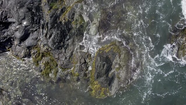 Aerial top down video of waves crashing over rocks in Jamestown, Rhode Island