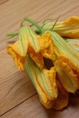 Bunch of orange Pumpkin flowers on wooden table. Cucurbita flowers