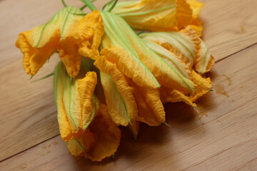 Bunch of orange Pumpkin flowers on wooden table. Cucurbita flowers