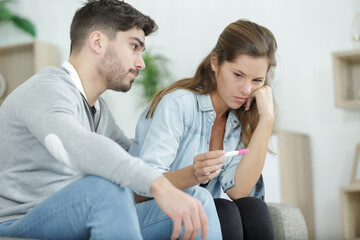 upset couple is looking at pregnancy test