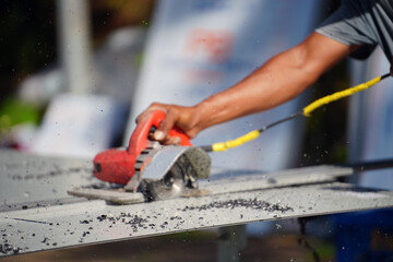 Worker use angle grinder cutting aluminium on job