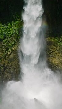 Waterfalls with rainbow in Lake Sebu, Hikong Bente falls in slow motion. Mindanao, Philippines. Vertical view.