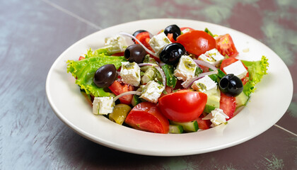Individual side serving of delicious fresh Greek salad with feta cheese, olives, tomatoes and salad greens