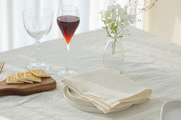 Wine glasses and white plates on white table.