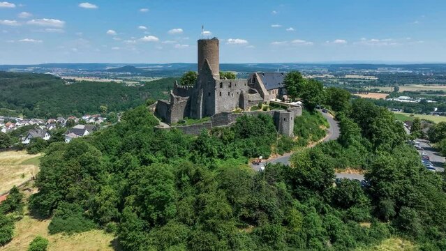 Ruins of medieval Gleiberg castle in Hesse, Germany, located on the top of a volcanic mountain. Aerial 4K revealing video in summer