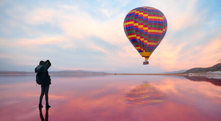 Hot air balloon flying over spectacular Maharlu pink lake at sunset - Shiraz, Iran