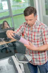 Man at photocopier holding package