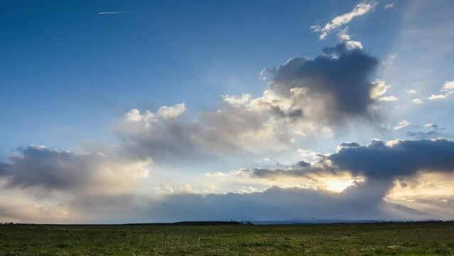 timelapse with blue sky and colorful clouds during rain and storm and sundown in a landscape