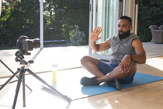 Happy African American Man Wearing Sportswear On Mat And Making Video Blog, Waving Hand At Home