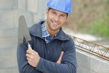 portrait of a male builder holding a trowel