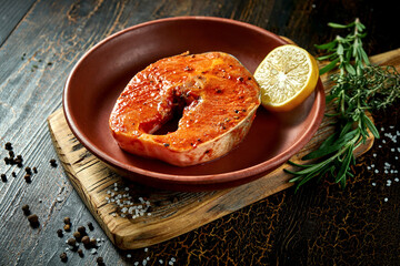 Marinated salmon steak in a clay plate. Delicious seafood