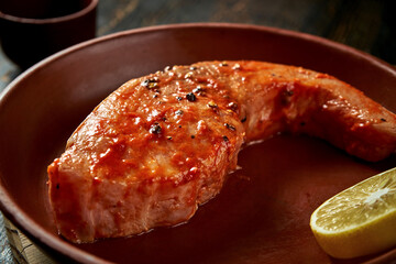 Marinated white carp steak in a clay plate. Delicious seafood