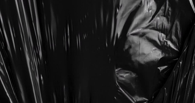 Surrender to the spellbinding charm of stretched plastic film as it merges with the depths of black, unveiling a tactile dreamscape that echoes the intricate beauty of rumpled cellophane wrap.
