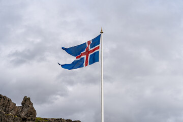 Icelandic flag waving against cloudy sky