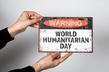 World Humanitarian Day 19 August. Warning sign with text on a white background