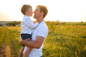 Father's day. Happy family father and toddler son playing and laughing on nature at sunset