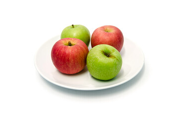 Green apples and red apples look fresh and appetizing on a white plate. Close up green apples and red apples on white dish with with background. isolated background.