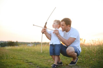 a man and a little boy doing archery
