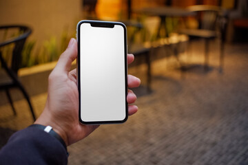 Hands of man holding smart phone with white screen for mockup