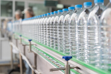Clean purified drinking plastic bottled water inside automated conveyor belt production line in drinking water factory