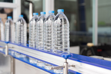 Clean purified drinking plastic bottled water inside automated conveyor belt production line in...