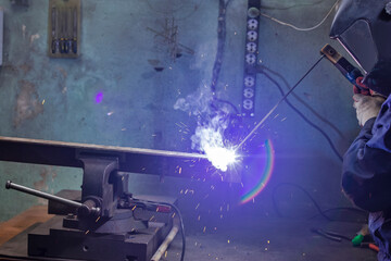Welding Concepts. Professional Industrial Welder Worker Labourer During Welding Process At Workshop With Steel Structure