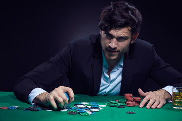 Concentrated Handsome Caucasian Brunet Young Pocker Player At Pocker Table With Chips While Playing.