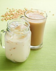 soya milk and iced soya bean drink with beans and green background