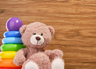 Nice teddy bear and pyramid with colored rings. Toys for kids. Copy space for text.