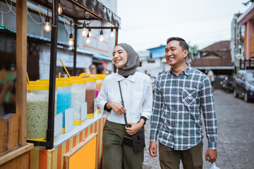 beautiful muslim couple are shopping in a food stall or street vendor during ramadan