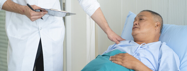 Doctor touching patient on the bed to encouragement mental of elderly patient after surgery at bed...