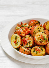 Herbs Garlic Potatoes in white bowl, top view