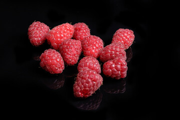 Ripe fresh raspberries on black background