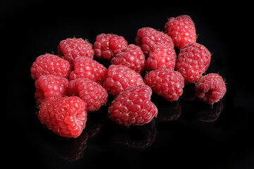 Ripe fresh raspberries on black background