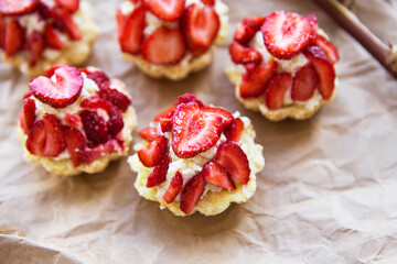 Very tasty muffins with fresh strawberries lie on kraft paper