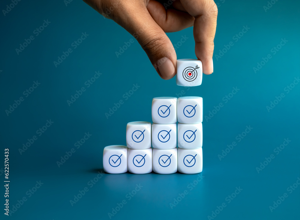 Poster business goal and success. target icon on white block put by hand on top of growth graph steps block