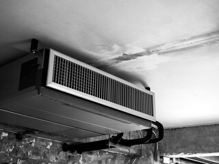 Black machine, modern air conditioning ceiling mounted ventilation system decoration on ceiling in old white construction building factory, loft style interior, black and white style.