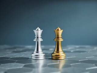 Golden and silver queen luxury chess pieces standing together on a silver hexagon pattern...