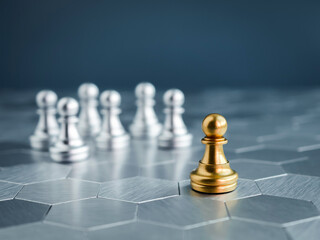 The golden pawn chess piece standing out from the group of silver pawn chess pieces on hexagon...