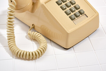 Analog, vintage phone with gray buttons beige color in close up. Aesthetic telephone concept.