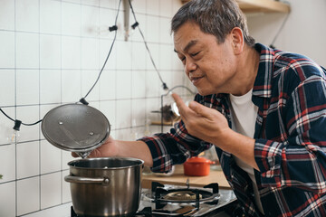 The retired man's eyes sparkle as he lifts the lid of the soup pot, enjoying the delicious fragrance in his home kitchen.