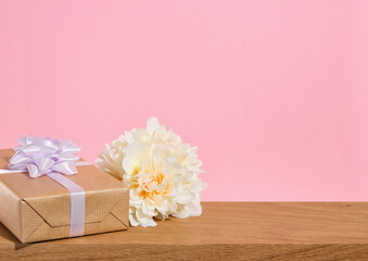 Holiday composition on a pink background. Birthday gift and holiday flowers. Romantic surprise.