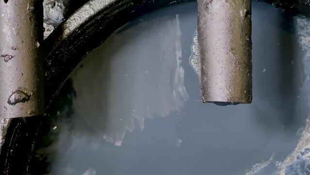 Black chemical wastewater coming out from pipe to storage tank from industrial processes. Hazardous and toxic waste
