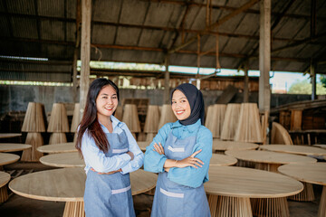 two female entrepreneurs stand with crossed hands at a woodcraft shop